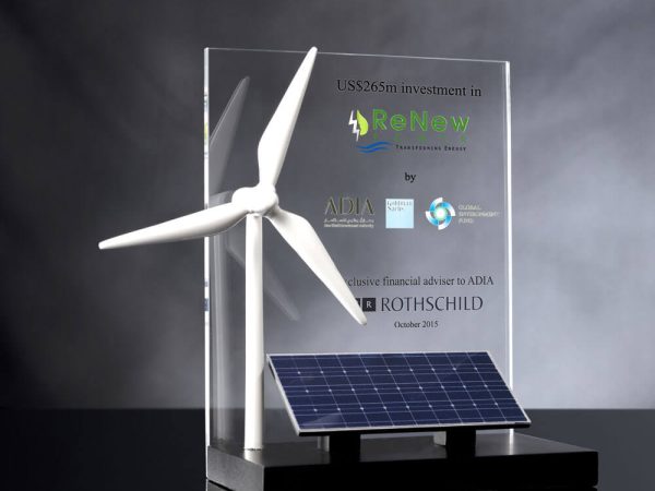 A wind turbine and solar panel on a stand, representing renewable energy source financial tombstone.