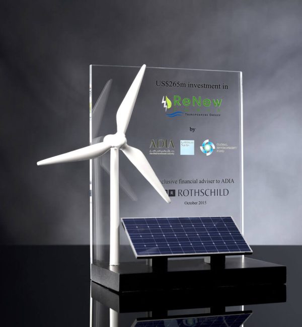 A wind turbine and solar panel on a stand, representing renewable energy source financial tombstone.